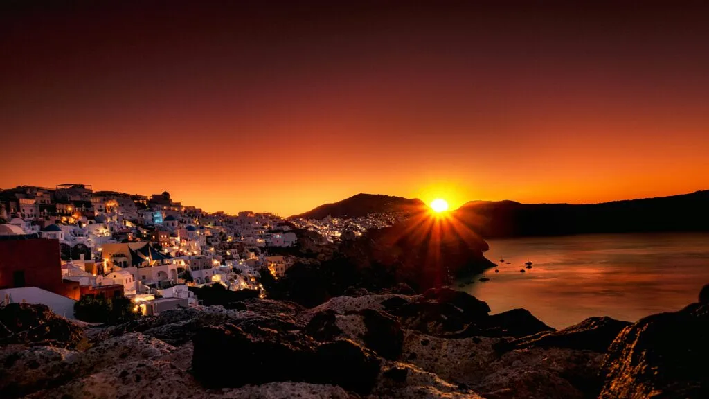 Sunset over Santorini, Greece. Greek Island with blue roofs and stark white buildings overlooking the sea.